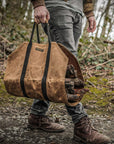 Tan waxed canvas firewood log carrier with webbing handles