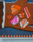 Colorful gemstone illustration on a textured surface with geometric patterns.