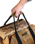 Tan waxed canvas firewood log carrier with webbing handles