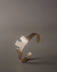 A handcrafted sculptural cuff bracelet featuring an abstract cut-out design inspired by modern art and vintage jewelry. Available in solid brass or sterling silver, this statement cuff combines bold geometric shapes with clean lines for an effortlessly modern look
