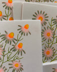 Floral patterned cards with orange centers and green leaves on a white background