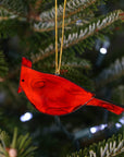 Made of semi-translucent red glass, this cardinal fire bird ornament can be used as a Christmas decoration, or a year-round accent. It hangs beautifully in a window, catching the sunlight, adding a charming quality to any space.