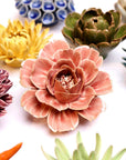 Colorful ceramic flower sculptures on a white background