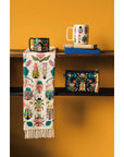 Add charm and protection to your kitchen with the Amulet Embroidered Dishtowel. Featuring insects, reptiles, flowers, and feathers in vibrant hues with playful tassels.
