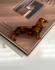 Show off your love for pups with this dachshund-shaped hair claw clip. Crafted from smooth brown acetate, it’s lightweight and easy to wear, keeping hair in place while adding a playful, whimsical touch to any look. Perfect for dog lovers or anyone who enjoys fun, animal-inspired accessories.