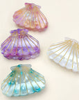 Bring a touch of beachy charm to your hairstyle with this pink shell-shaped hair claw clip. Made from lightweight acrylic, it holds hair securely while adding a playful, summery accent to any look. Perfect for everyday wear or for layering with other clips for a fun, stylish statement.
