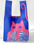 Add a playful pop to your look with this knitted shoulder bag featuring a whimsical blue and red cat graphic. Soft and lightweight, it’s perfect for carrying your essentials while adding a fun, artistic touch to any outfit. The roomy, flexible design makes it a charming everyday companion.