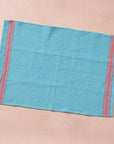 Brighten your kitchen with a pop of color and timeless charm. This striped woven tea towel blends function with simple elegance, featuring a refreshing aqua and white base accented by three bold red stripes at each end. Crafted from 100% cotton, it’s soft, absorbent and ready to tackle daily tasks - from drying dishes to lining a breadbasket. A convenient cotton loop in the corner makes it easy to hang and display. Whether you’re cooking up memories or cleaning up spills, this towel adds a cheerful, artisan