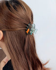 Add a little whimsy to your hairstyle with this mini koi fish claw clip. Made from smooth acetate with a sweet, sculptural silhouette, it brings a playful touch to half-ups, twists, and quick on-the-go styling. Lightweight, petite, and delightfully detailed, it’s an easy way to brighten your everyday look.