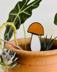 Handcrafted amber stained glass mushroom adds charm to plants or gardens. Weatherproof and pet-safe. Perfect for unique home decor and garden gifts.