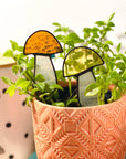 Handcrafted amber stained glass mushroom adds charm to plants or gardens. Weatherproof and pet-safe. Perfect for unique home decor and garden gifts.
