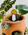 Handcrafted amber stained glass mushroom adds charm to plants or gardens. Weatherproof and pet-safe. Perfect for unique home decor and garden gifts.