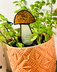 Handcrafted amber stained glass mushroom adds charm to plants or gardens. Weatherproof and pet-safe. Perfect for unique home decor and garden gifts.