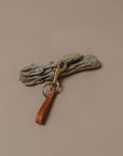 Tan colored leather keychain with a brass swivel clip and a solid brass rivet.