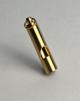 Brass whistle with a keyring loop, standing upright on a light gray background