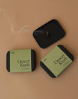 Simply light to fill your space with bright notes of tangerine and cannabis flower that settle into a amber vetiver smoke. Tin contains 25 Incense Cones - Resin + Fragrance Top Notes: tangerine, bergamot Heart Notes: cannabis flower, cypress, moss Base Notes: amber, leather, vetiver