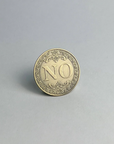 Bronze-finished coin showing NO, standing on a light gray background