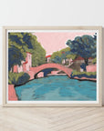 Embark on a visual journey to the heart of San Antonio with this enchanting print, capturing the essence of a leisurely stroll along the iconic River Walk. Offering the best of both worlds, immerse yourself in the charm of shops and restaurants while enjoying the scenic beauty of a riverside promenade. Created by Austin-based artist El Baker, this artwork transforms Texas landscapes into playful masterpieces, ensuring your home is adorned with vibrant colorways that spark joy and bring a touch of San Antoni