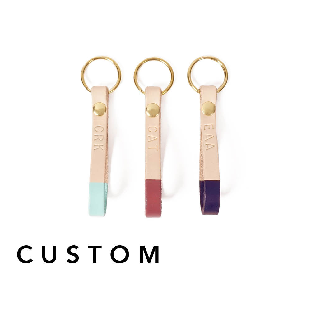 Hand-painted in bold accent colors on genuine leather and is the optimal size for carrying your keys in style. This key fob has a solid rivet and key ring of your choice, and features up to three hand-tooled initials! Hand-painted in bold accent colors on natural veg-tanned leather, this key fob has a solid brass rivet and split ring, and is the optimal size for carrying your keys in style. Available in your choice of any of our custom colors.