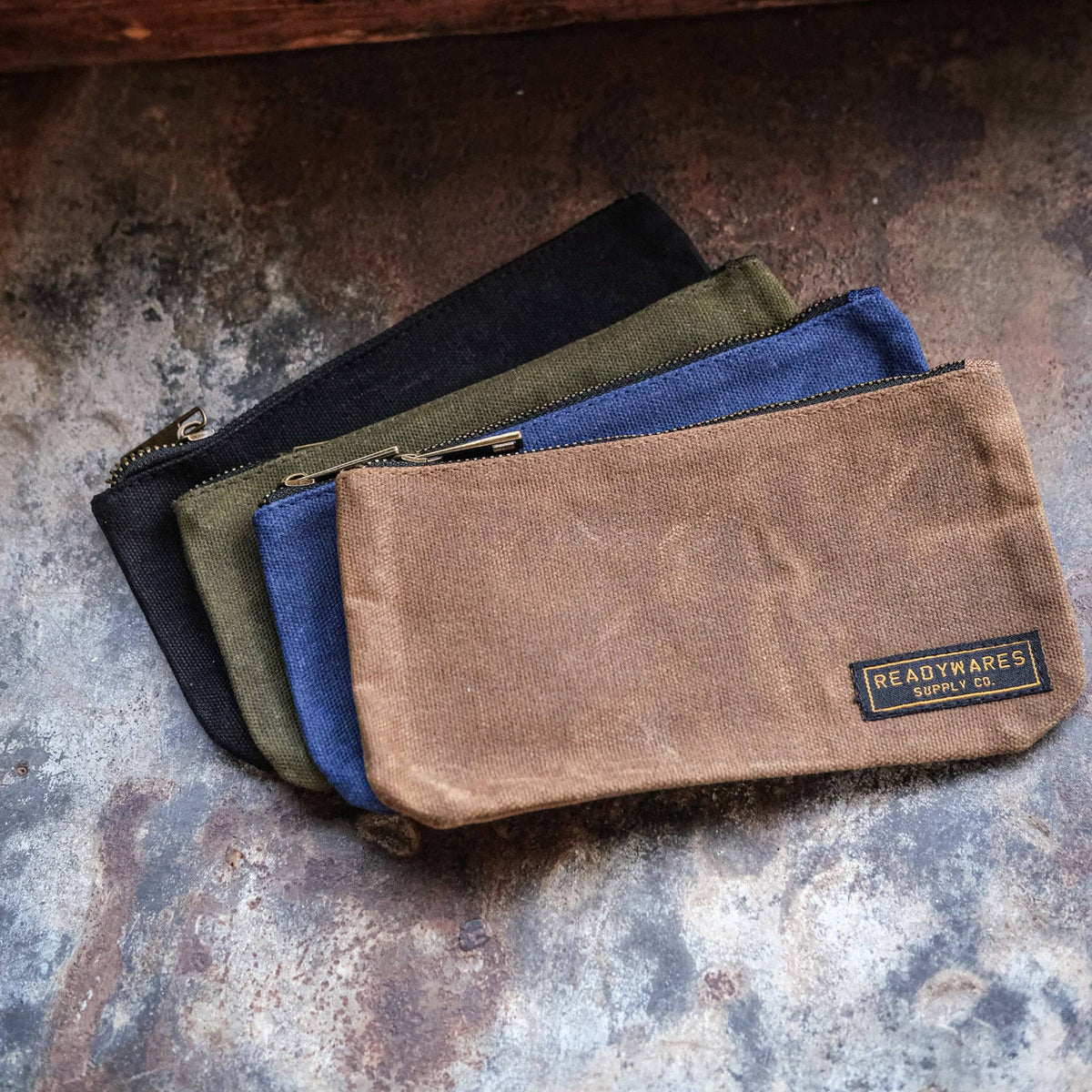 Waxed canvas zip pouches in tan, olive, navy and black
