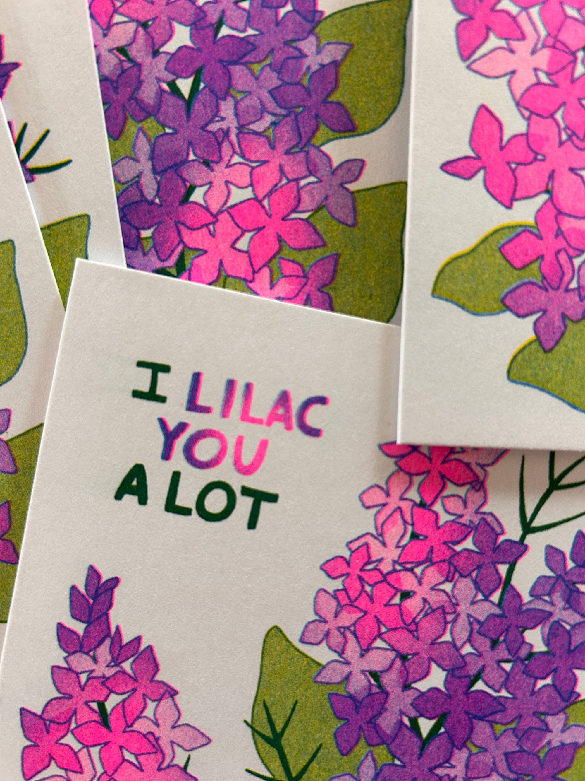 Card with lilac flowers and text 'I Lilac You A Lot' on a white background