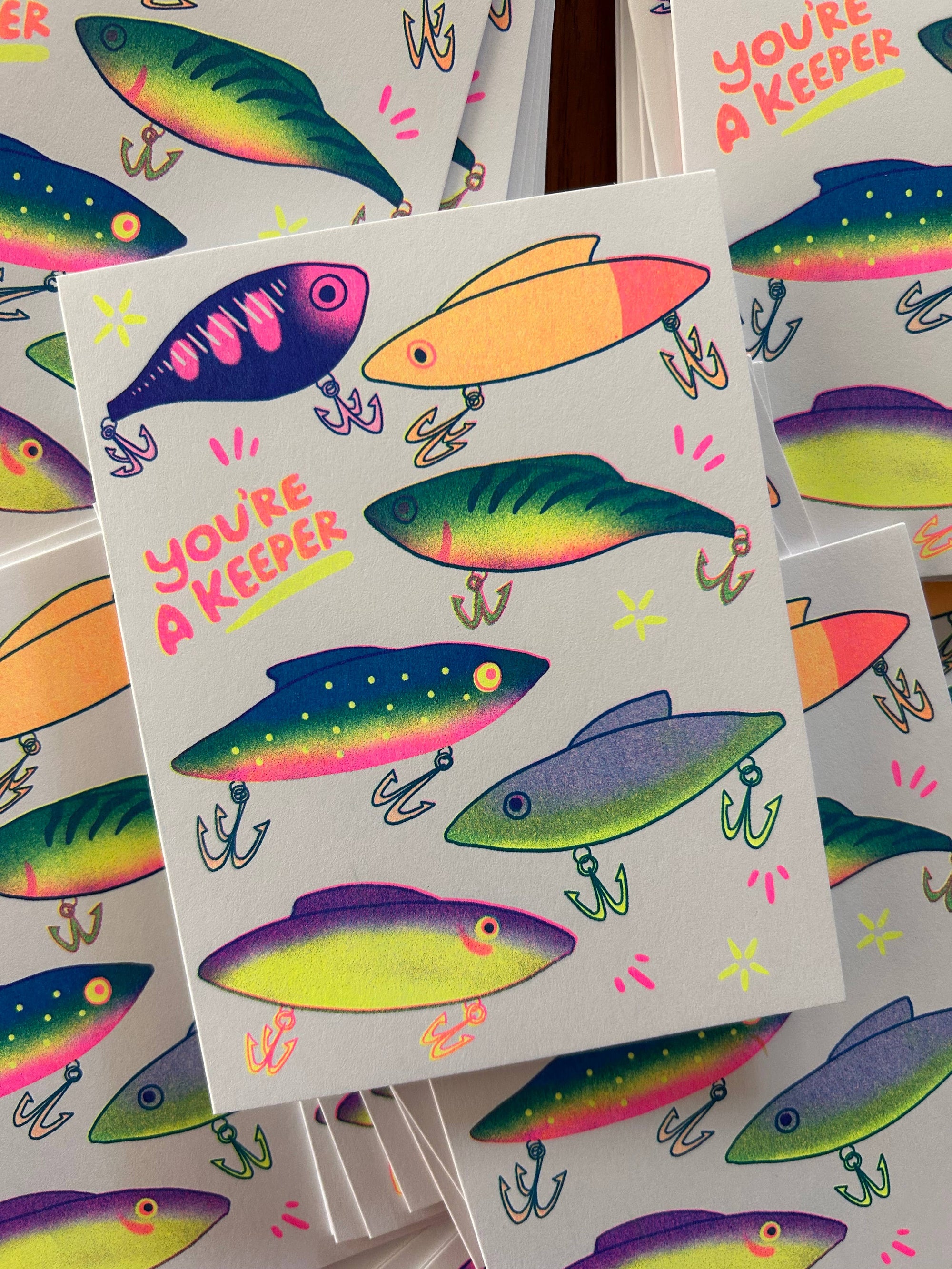 Colorful fishing lure stickers with 'You're a Keeper' text on a white background.