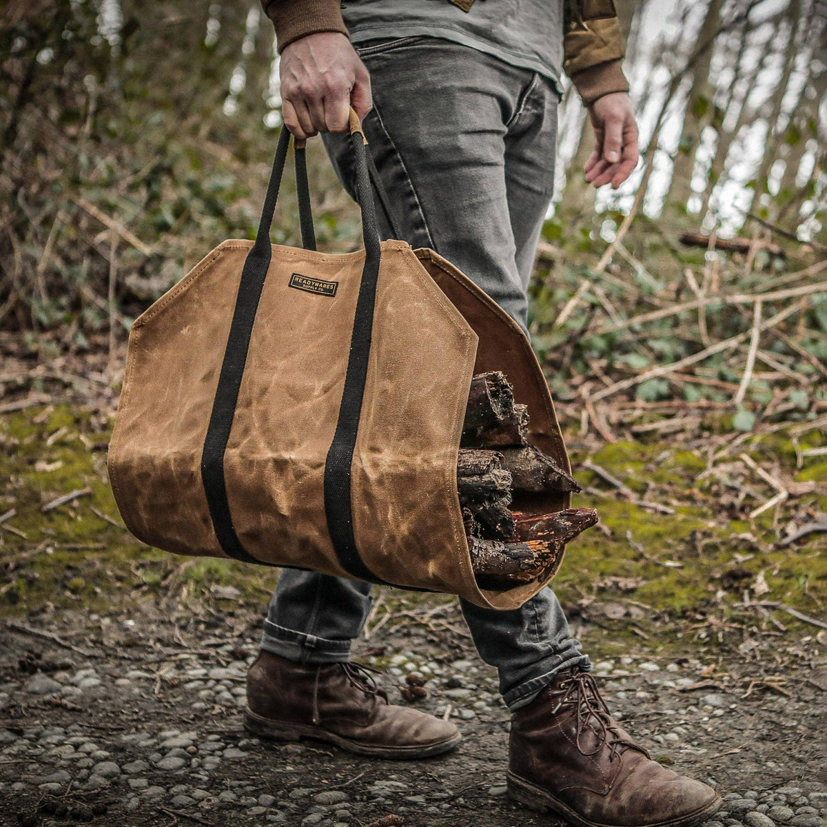 Tan waxed canvas firewood log carrier with webbing handles