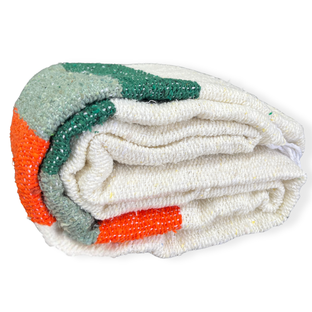 Cream Sea Breeze blanket with green and orange stripes rolled up on a white background
