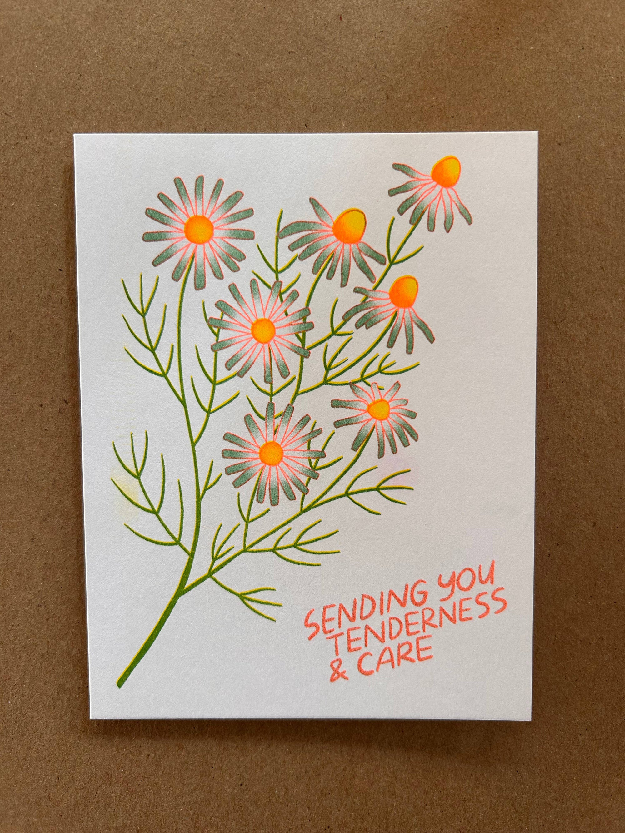 Card with floral design and text 'Sending you tenderness &amp; care' on a brown background