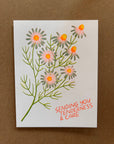 Card with floral design and text 'Sending you tenderness & care' on a brown background