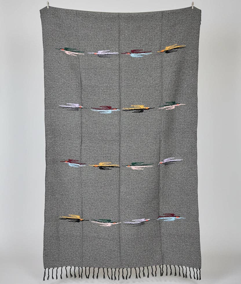 Charcoal wool blanket with rows of colorful woven thunderbirds, hanging flat