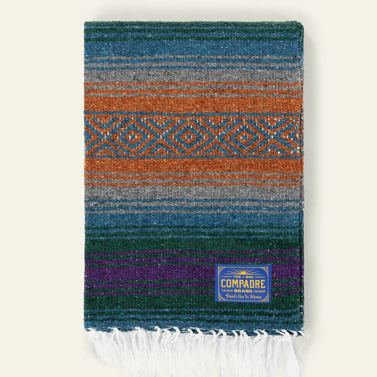 Falsa blanket in teal, rust, blue and purple stripes with a rust diamond band