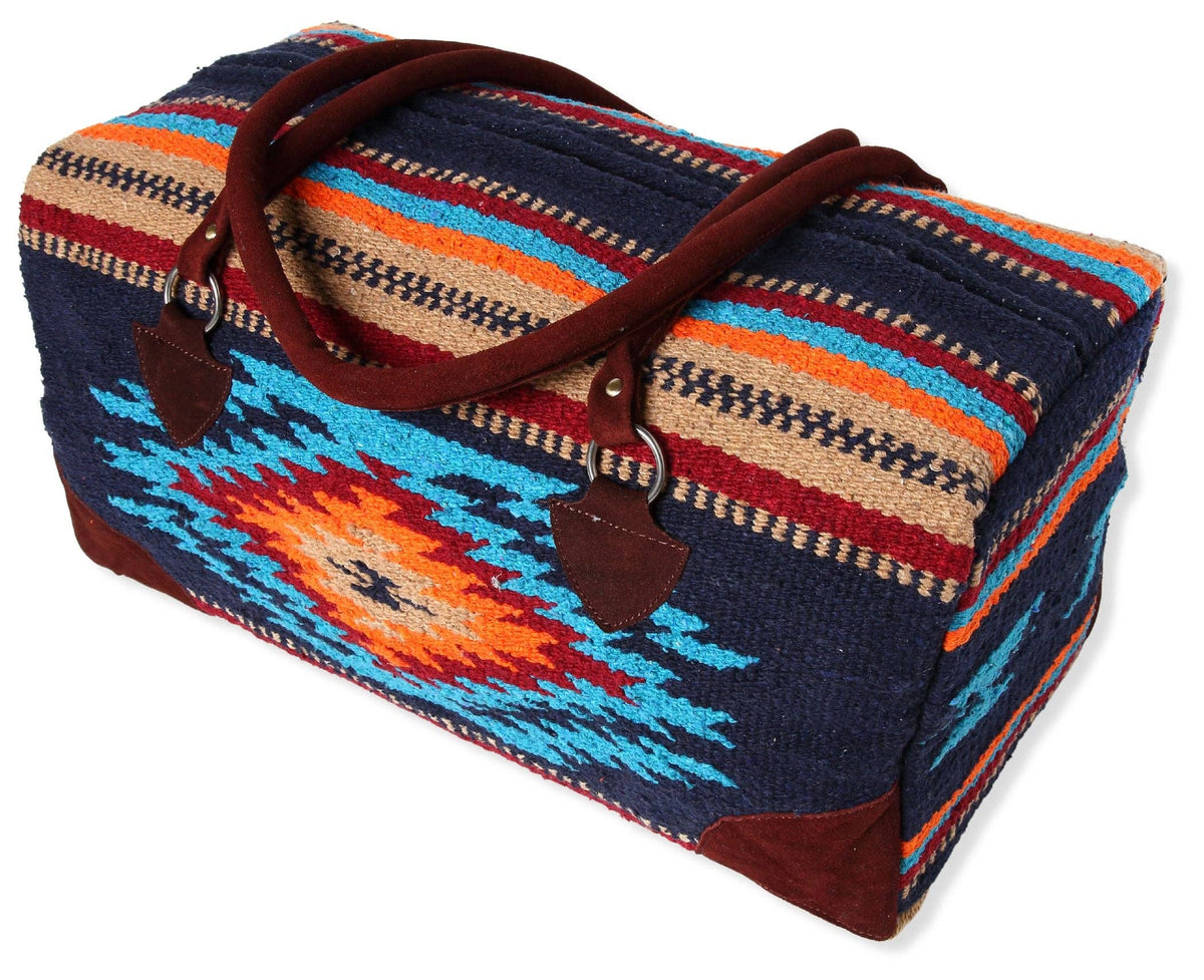 Navy handwoven duffel bag with turquoise, orange and red Southwest diamond pattern and brown suede handles, on a white background