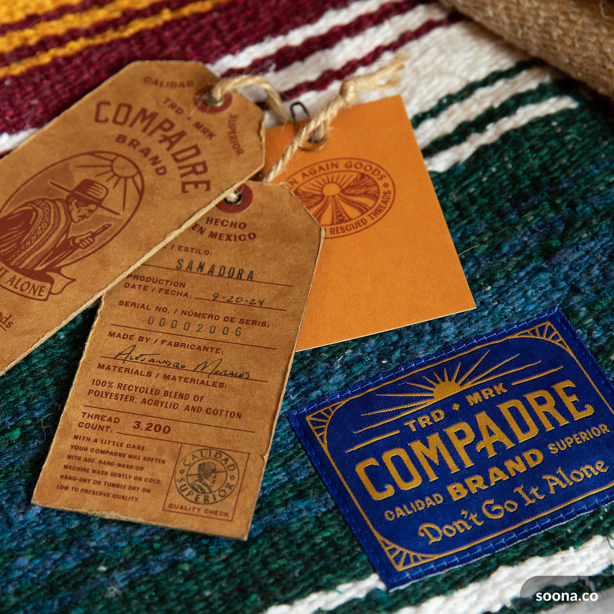 Compadre leather hang tags and woven brand label on a striped blanket