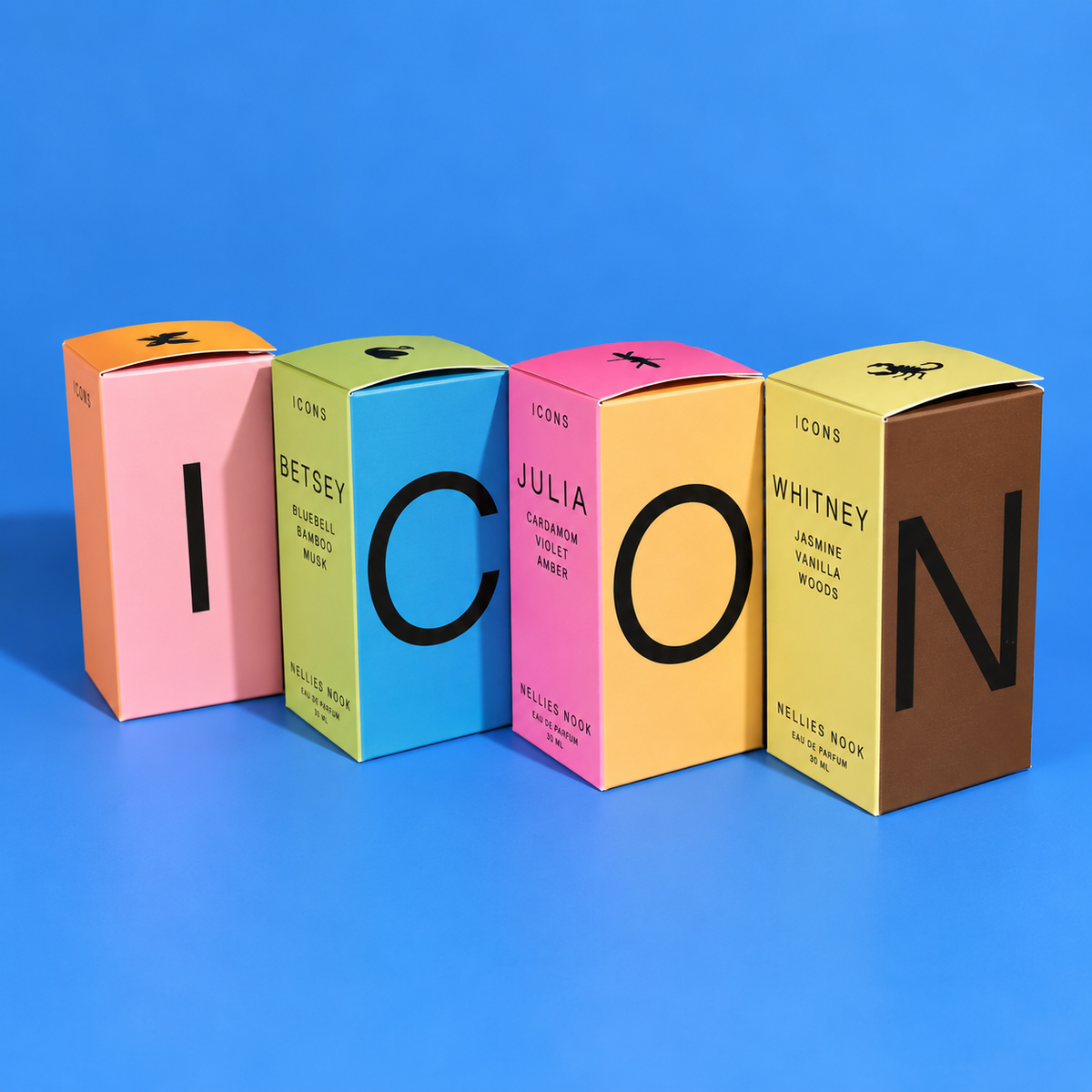 Four Icons perfume boxes spelling ICON on a blue background, including Betsey, Julia and Whitney