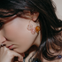 Model with dark hair wearing a Vari hoop with pink, clear and amber glass spheres