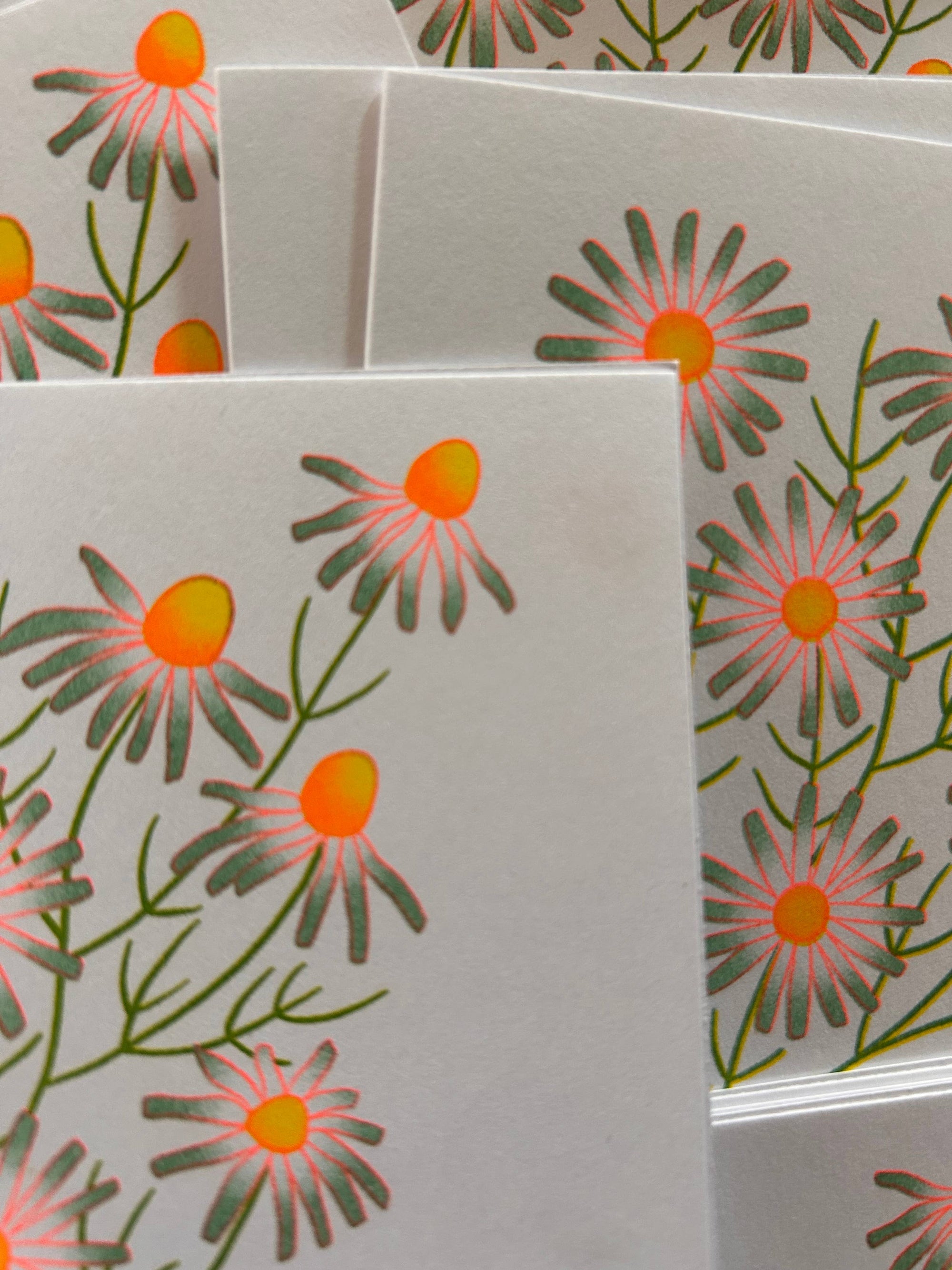 Floral patterned cards with orange centers and green leaves on a white background