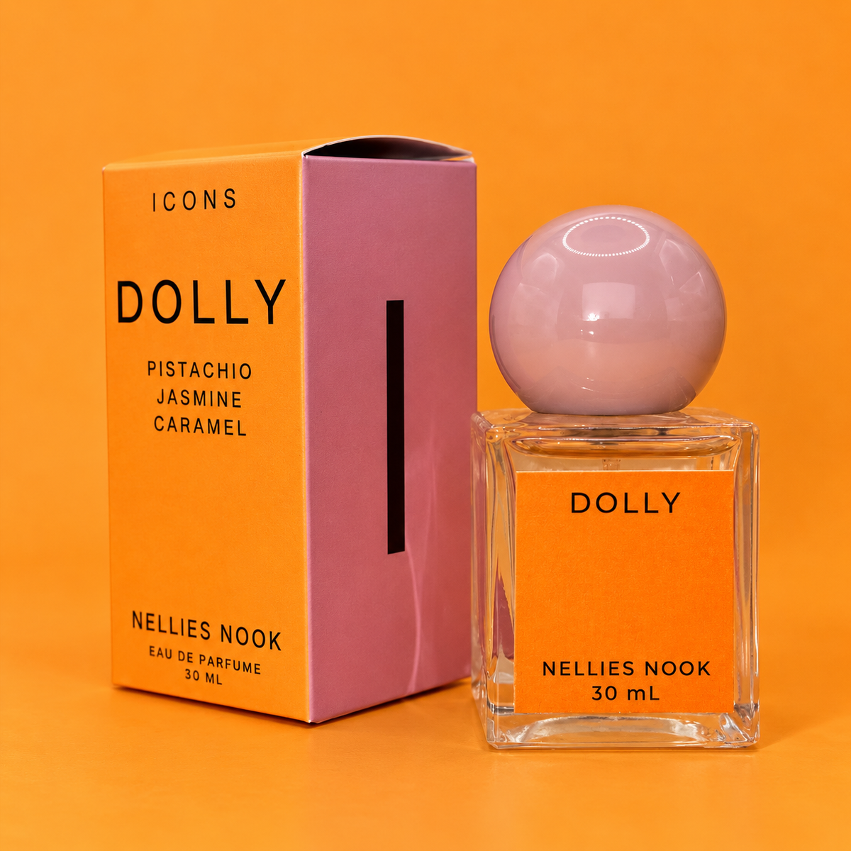 Orange Icons Dolly box beside a glass perfume bottle with a pink sphere cap and orange label, on an orange background