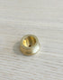 Small brass pot incense holder on a white wood surface
