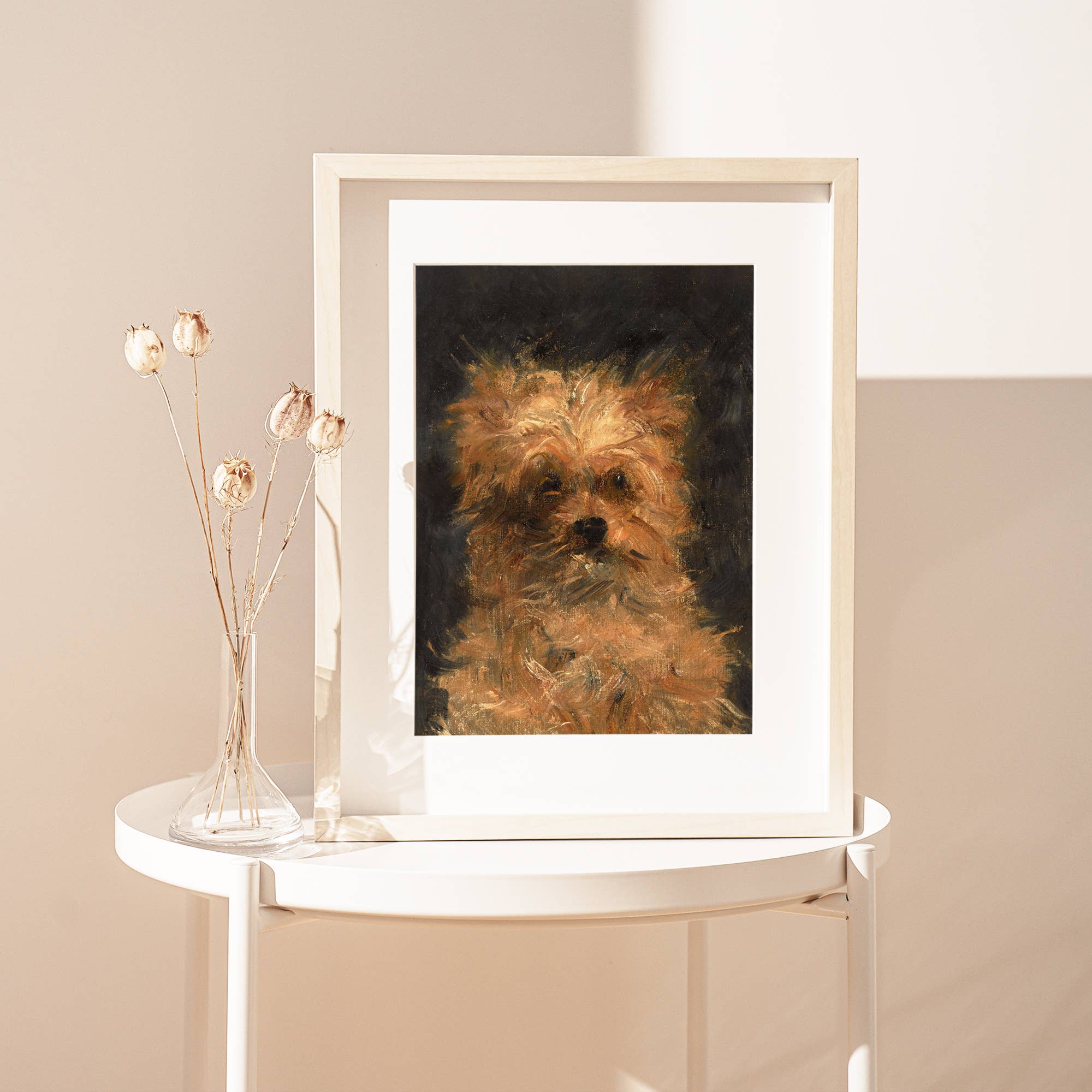 Framed portrait of a dog on a white table against a beige wall