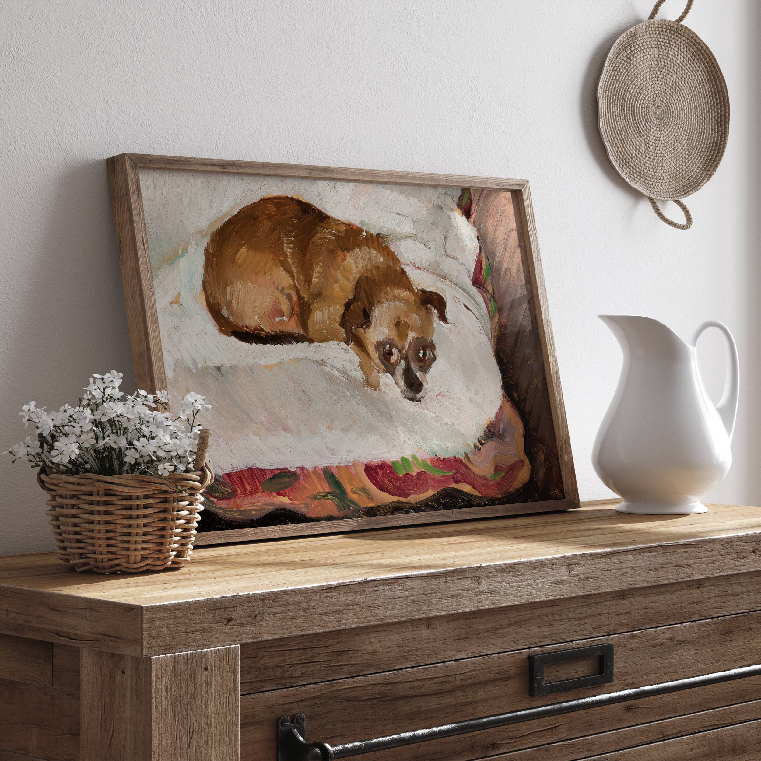 Framed painting of a dog on a wooden surface with a pitcher and basket.