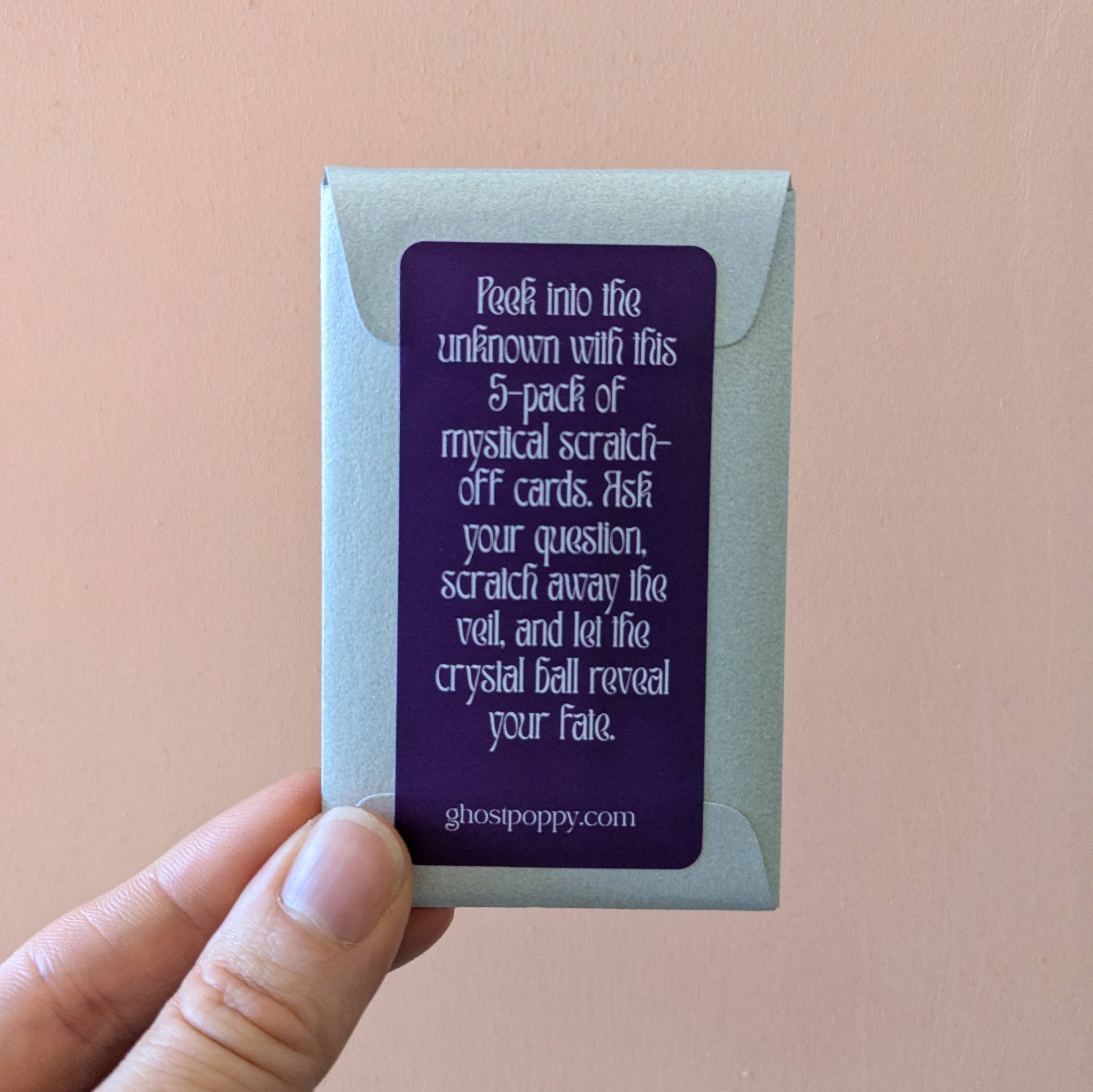 Hand holding a pack of scratch-off cards with text on a beige background