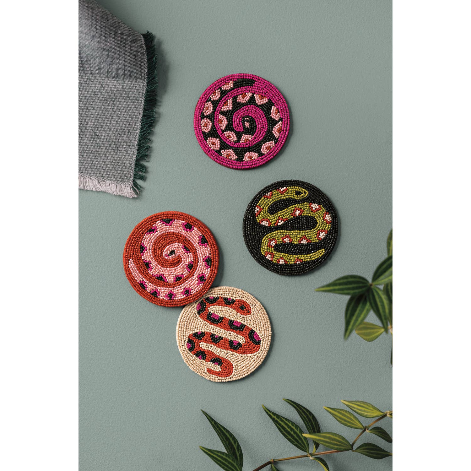 Set of 4 beaded coasters from Danica Studio’s Gardenland collection featuring bold snakes in earthy greens with pops of pink and red. Durable and eye-catching.