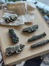 Assortment of brass animal pocket knives on a stone slab
