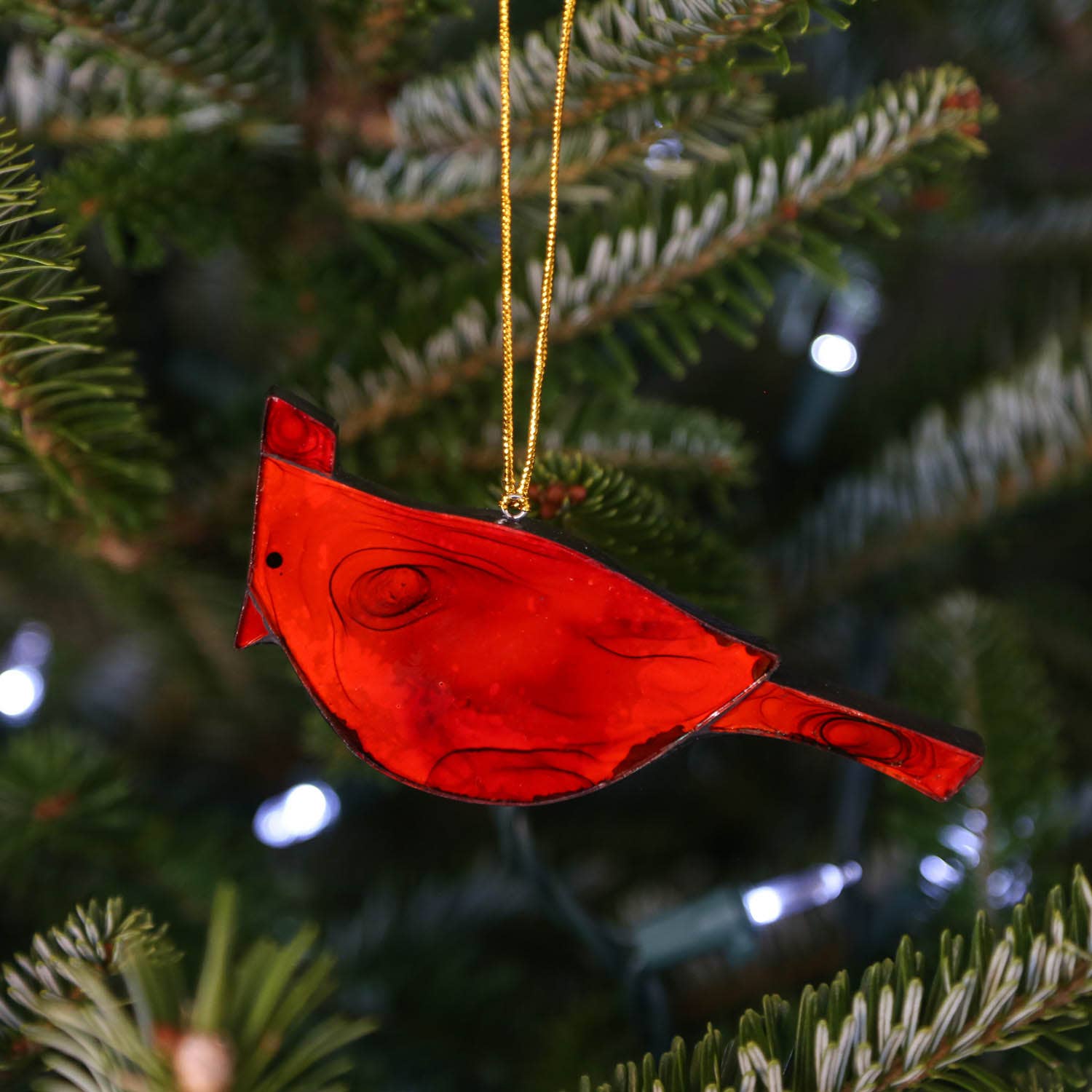 Made of semi-translucent red glass, this cardinal fire bird ornament can be used as a Christmas decoration, or a year-round accent. It hangs beautifully in a window, catching the sunlight, adding a charming quality to any space.
