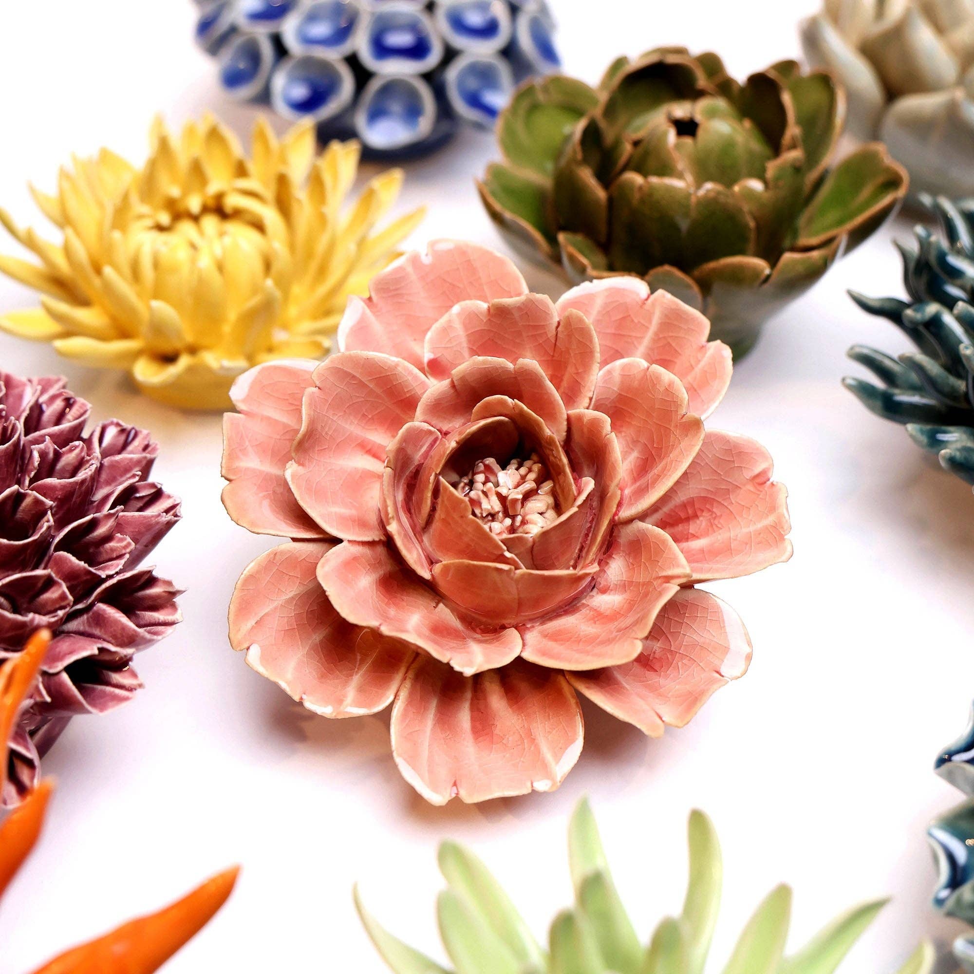 Colorful ceramic flower sculptures on a white background