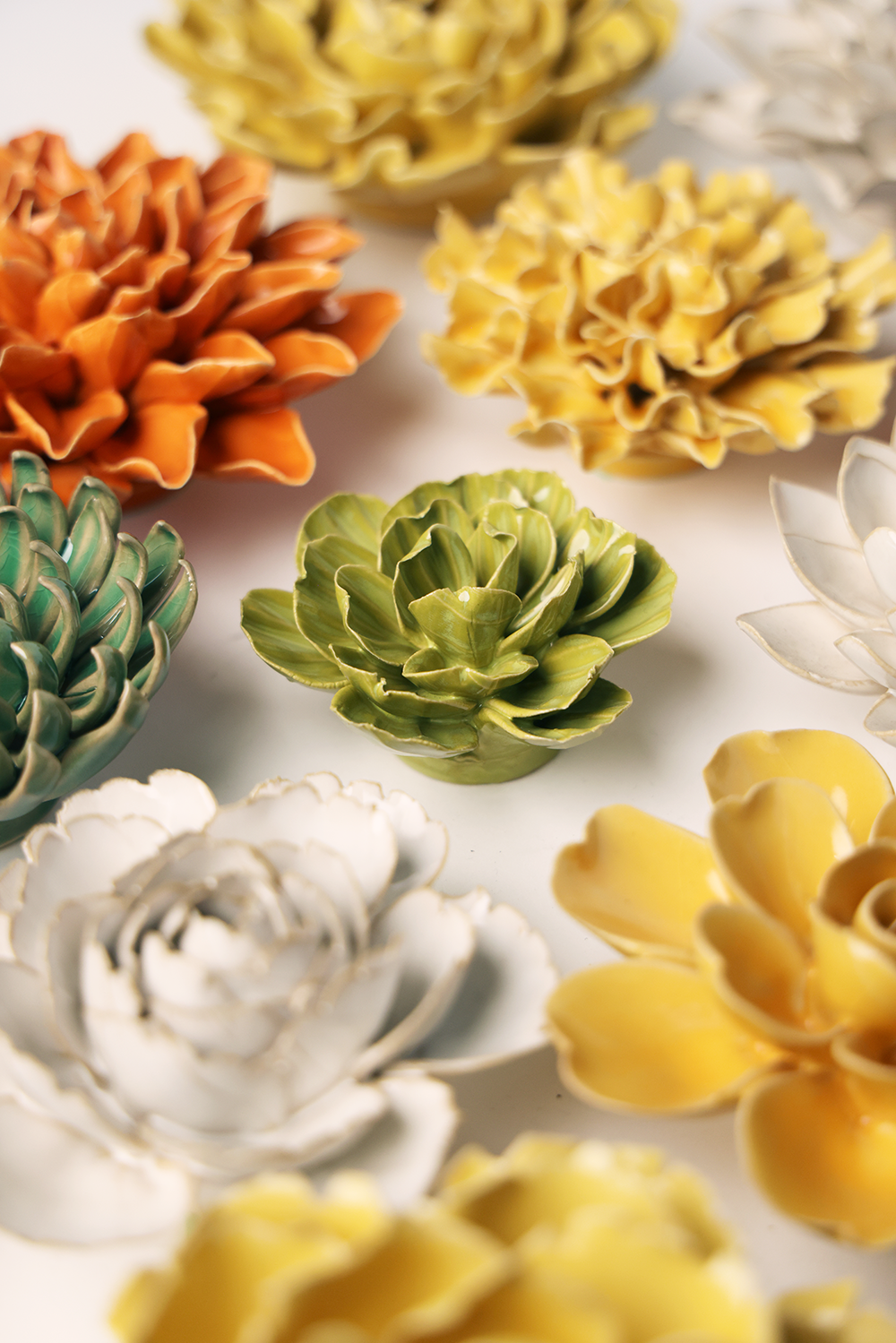Colorful ceramic flower sculptures on a light background