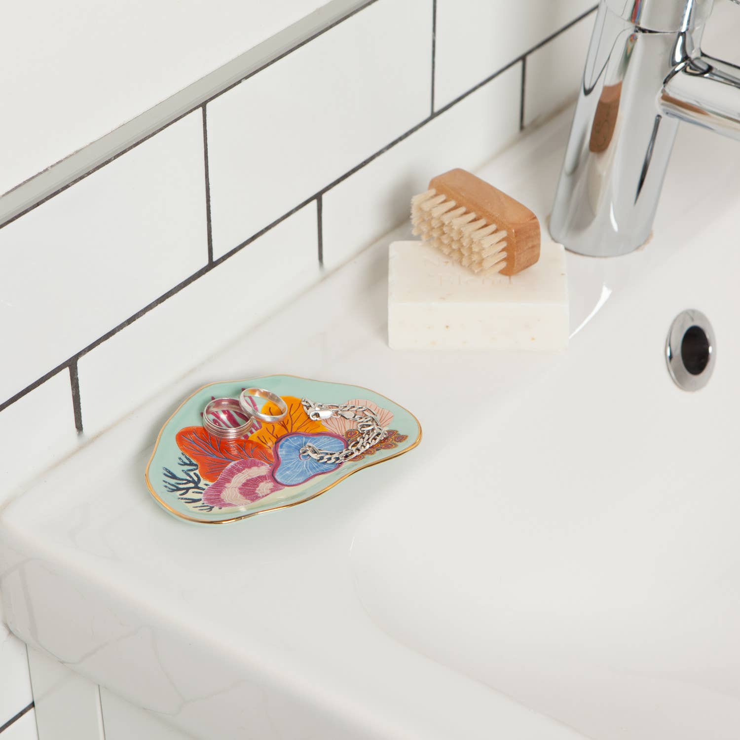 Dive into an otherworldly realm of brilliant luminosity with this ocean-themed Neptune Trinket Tray. Immersed in a warm, tropical sea of pale aqua, a colorful coral garden is the ideal home for favorite jewelry, treasured trinkets and small everyday essentials in the bedroom or bathroom.