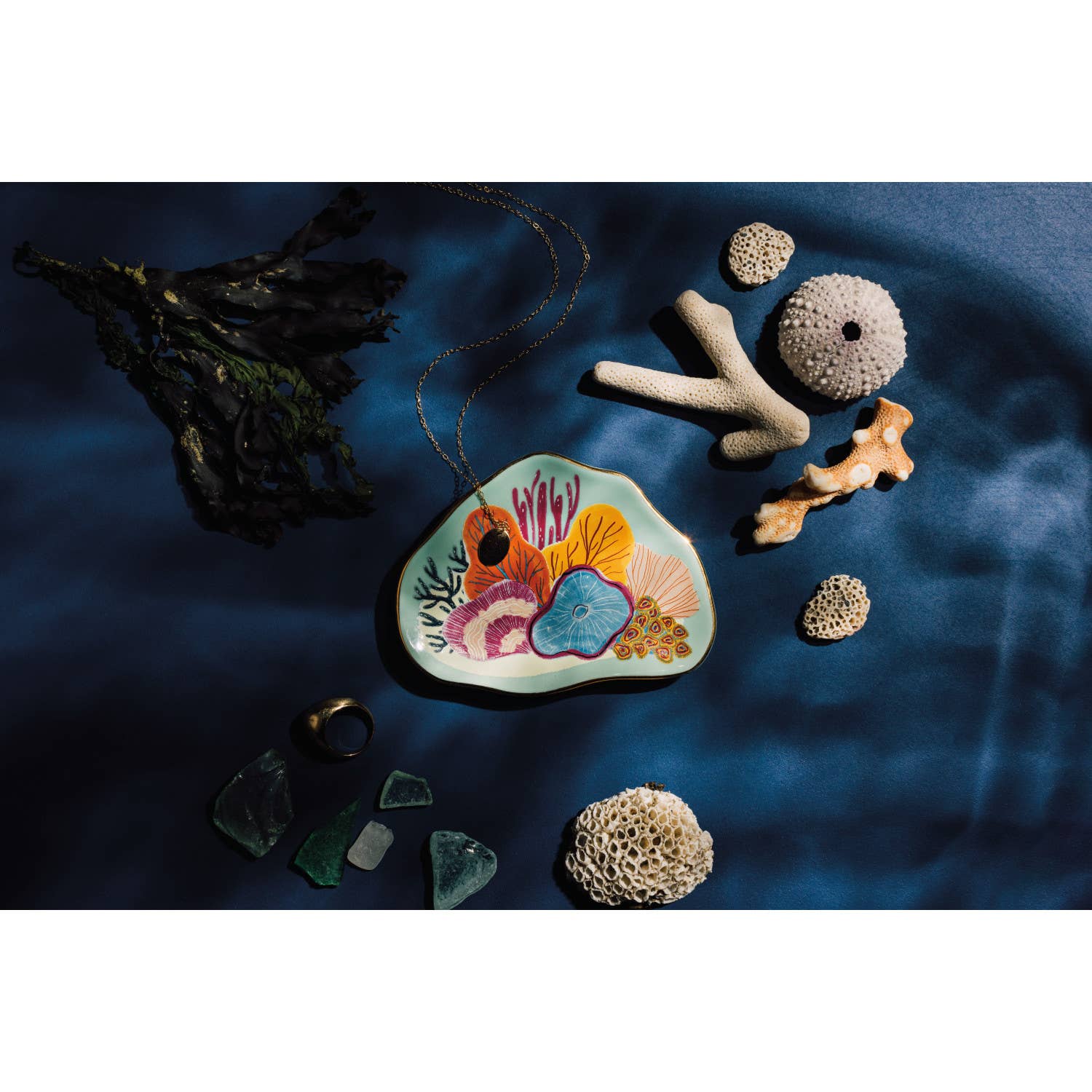 Dive into an otherworldly realm of brilliant luminosity with this ocean-themed Neptune Trinket Tray. Immersed in a warm, tropical sea of pale aqua, a colorful coral garden is the ideal home for favorite jewelry, treasured trinkets and small everyday essentials in the bedroom or bathroom.