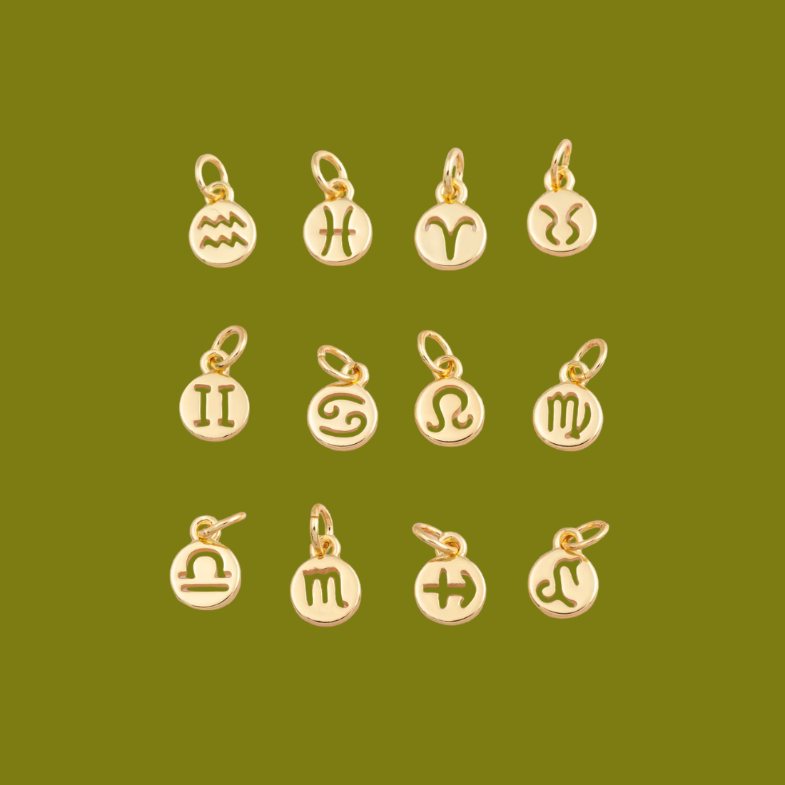 Gold zodiac charm pendants on a green background